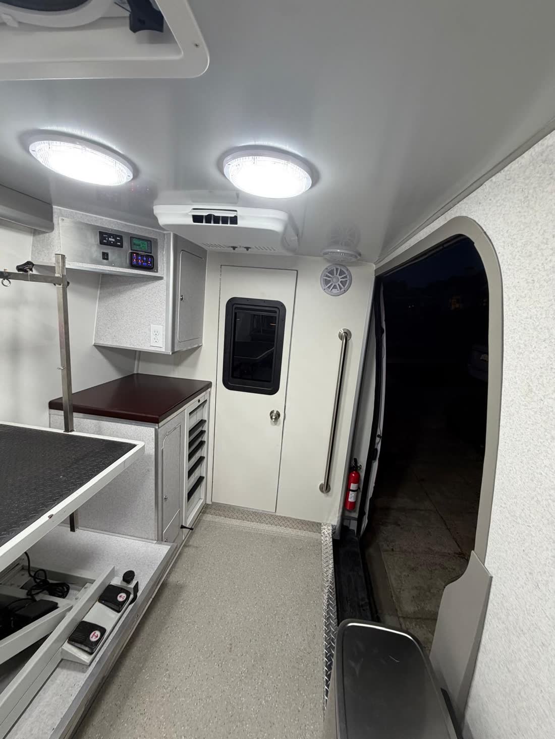 View toward the front: LED lights, ceiling A/C, cabinet and bulkhead door